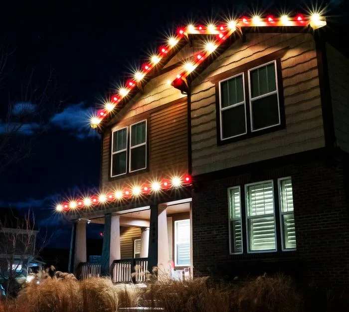 Classic red and white C9 lights along a Denver home's roofline